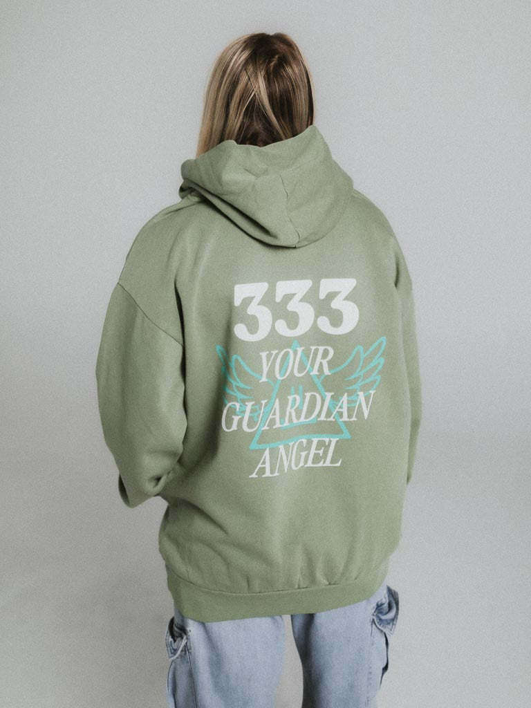 A woman wearing a green hoodie with the number 333 on it